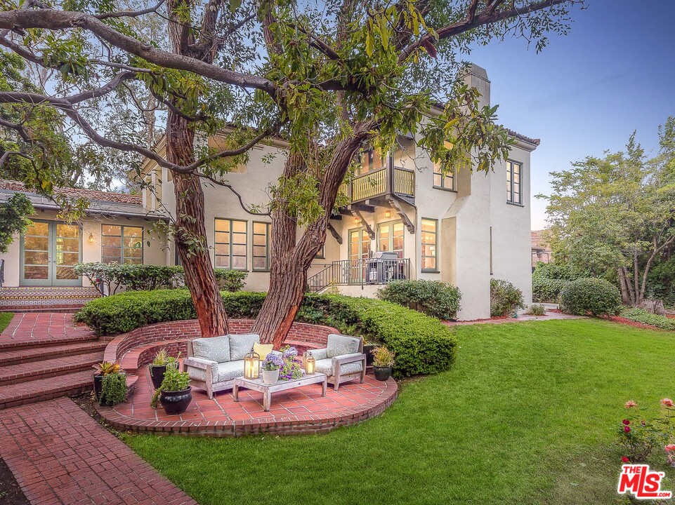 12730 Sunset Boulevard Los Angeles, CA 90049 - Photo 4 of 51 a view of a backyard with table and chairs potted plants and large tree