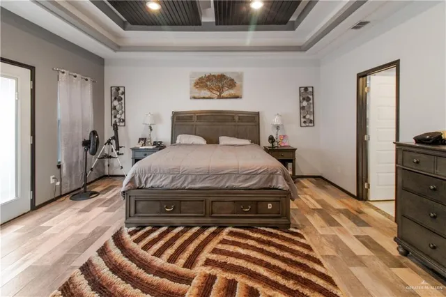 a bedroom with a bed and wooden floor