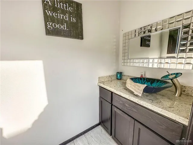 a bathroom with a granite countertop sink and a mirror