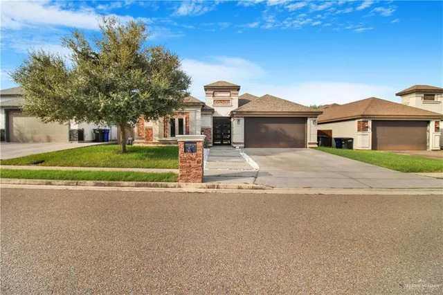 a front view of a house with a garden and trees