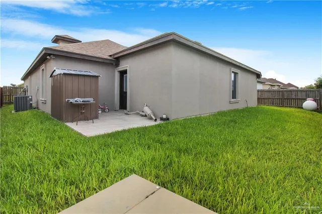 a backyard of a house with table and chairs