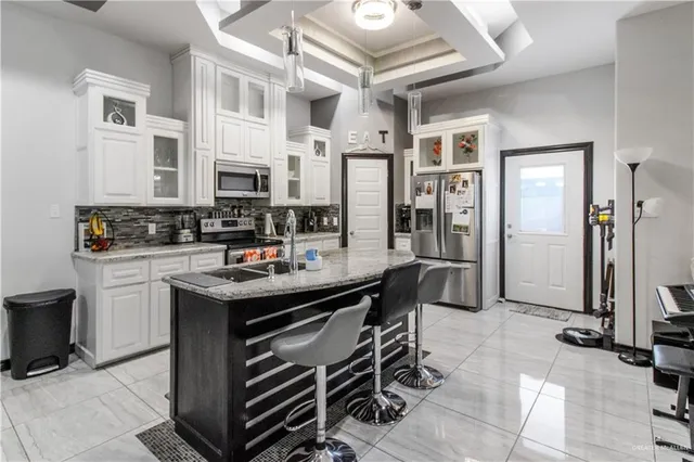 a kitchen with stainless steel appliances kitchen island granite countertop a sink and cabinets