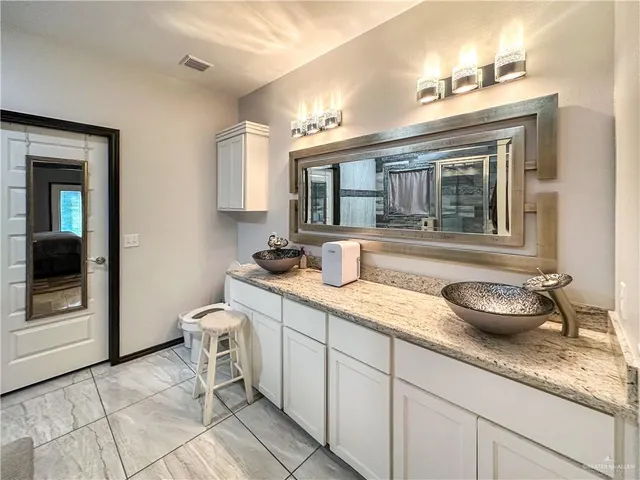a bathroom with a granite countertop sink and a mirror