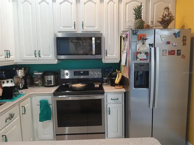 a kitchen with stainless steel appliances granite countertop a stove and a refrigerator