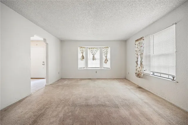 an empty room with windows and closet