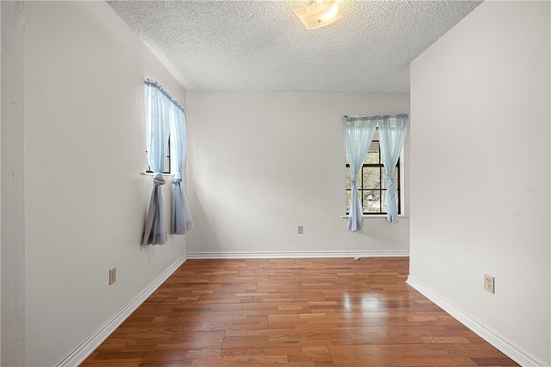 3087 Lenore Avenue Ingleside, TX 78362 - Photo 18 of 29 a view of an empty room with wooden floor and a window