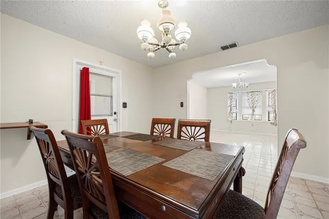 a view of a dining room with furniture and a chandelier