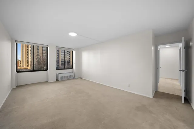 an empty room with windows and closet