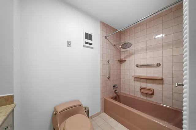 a bathroom with a granite countertop bathtub shower and toilet