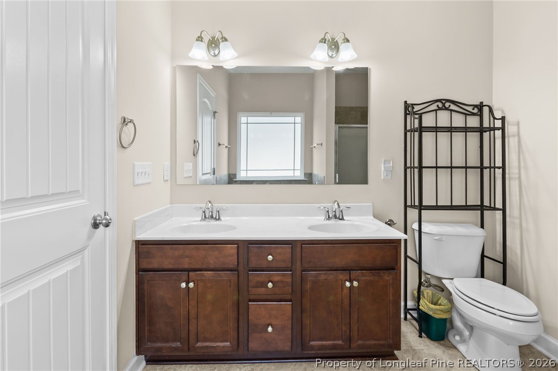 216 Meherrin Loop Raeford, NC 28376 - Photo 19 of 38 a bathroom with a toilet a sink and mirror