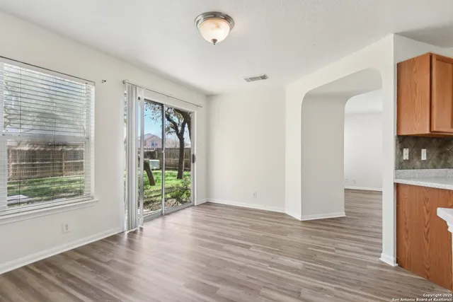 a view of hallway with wooden floor and fan