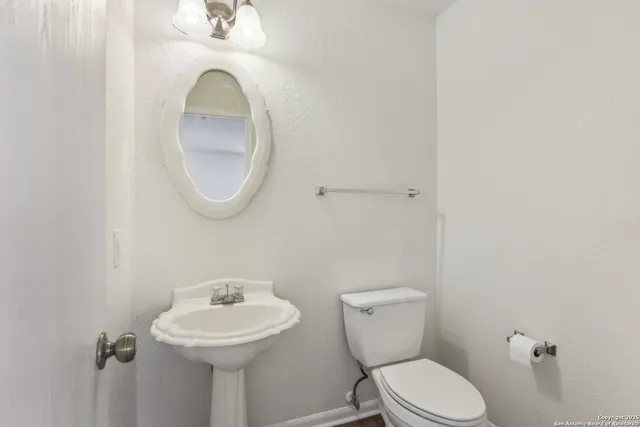 a bathroom with a toilet sink and mirror
