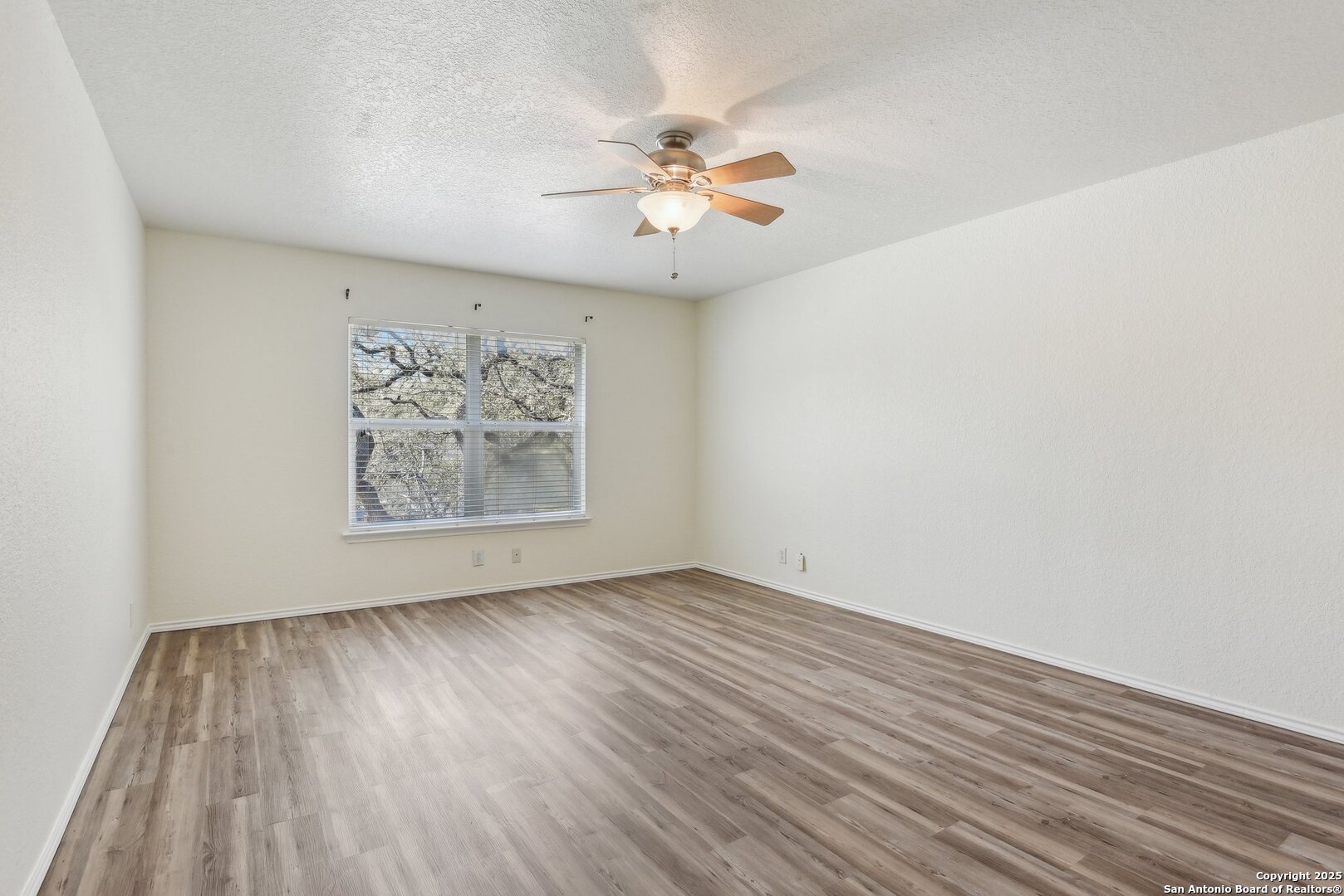 16216 Ike Lane Selma, TX 78154 - Photo 20 of 40 a view of an empty room with wooden floor and a ceiling fan