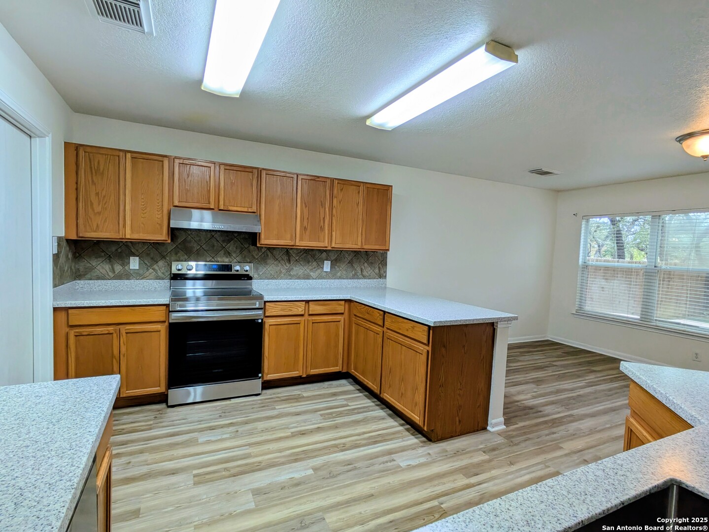 16216 Ike Lane Selma, TX 78154 - Photo 10 of 40 a kitchen with wooden floors and wooden cabinets