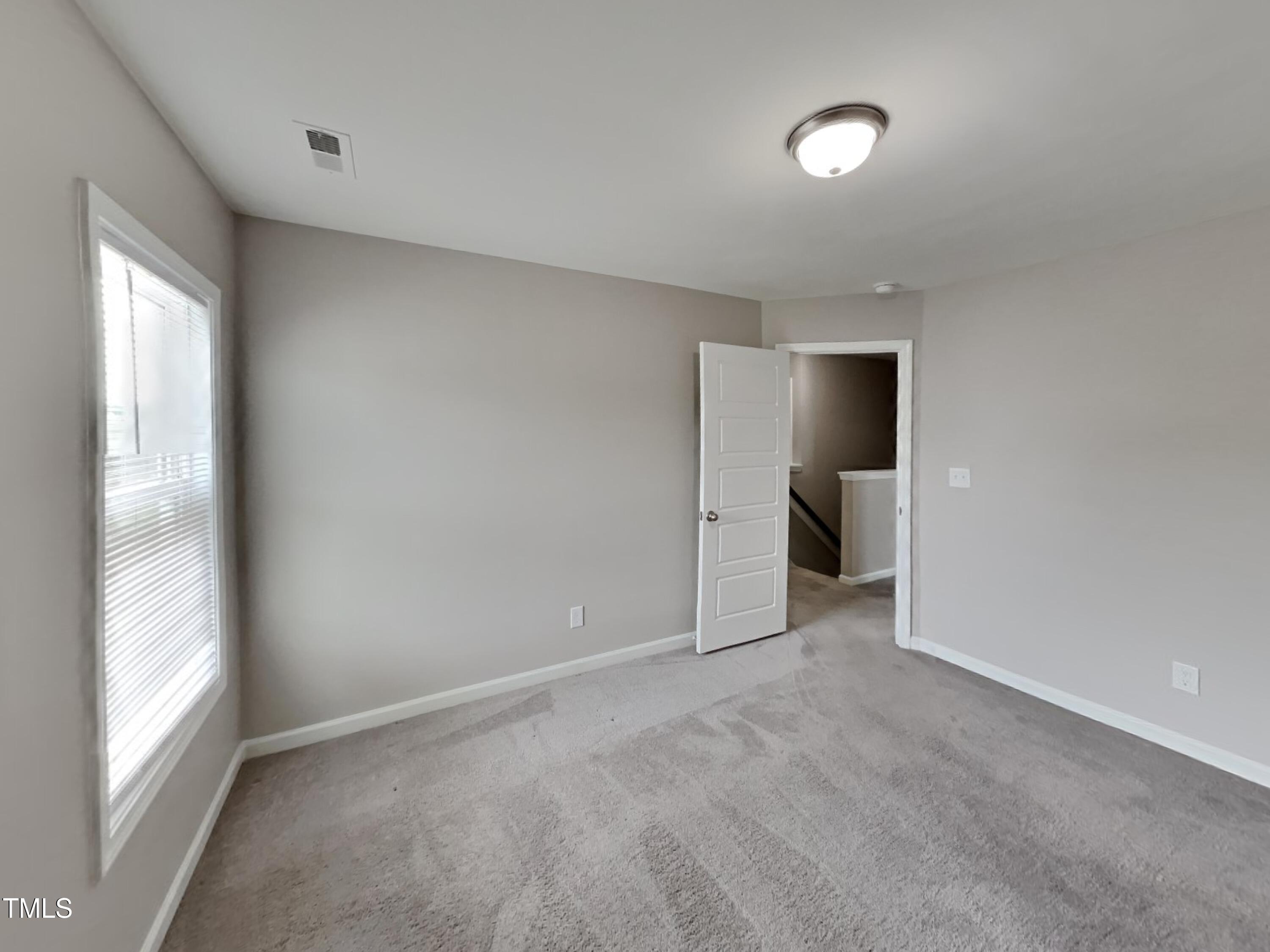 67 Weathervane Dr. Zebulon, NC 27597 - Photo 13 of 17 a view of an empty room with a bathroom and a window