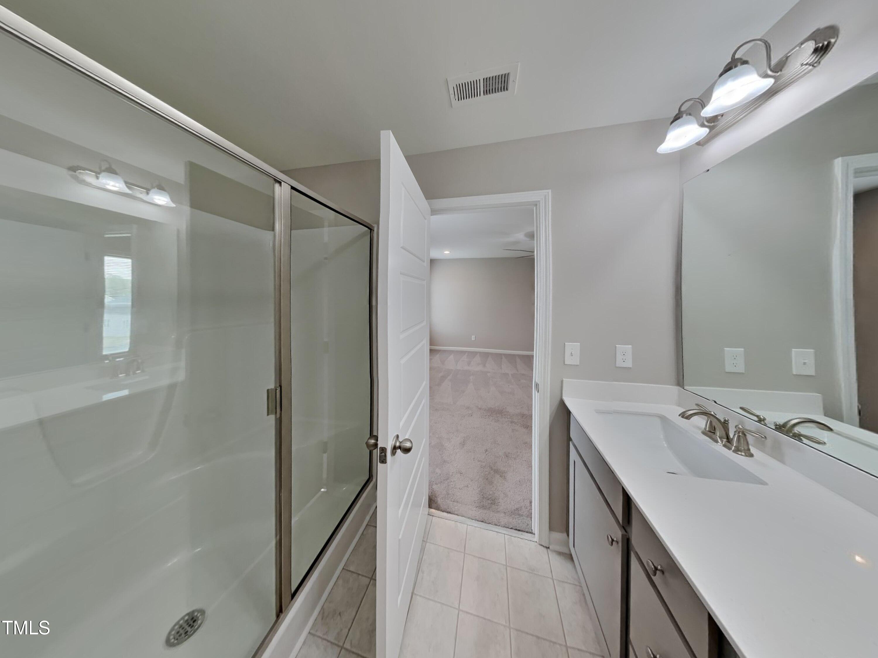 67 Weathervane Dr. Zebulon, NC 27597 - Photo 9 of 17 a bathroom with a double vanity sink mirror and shower