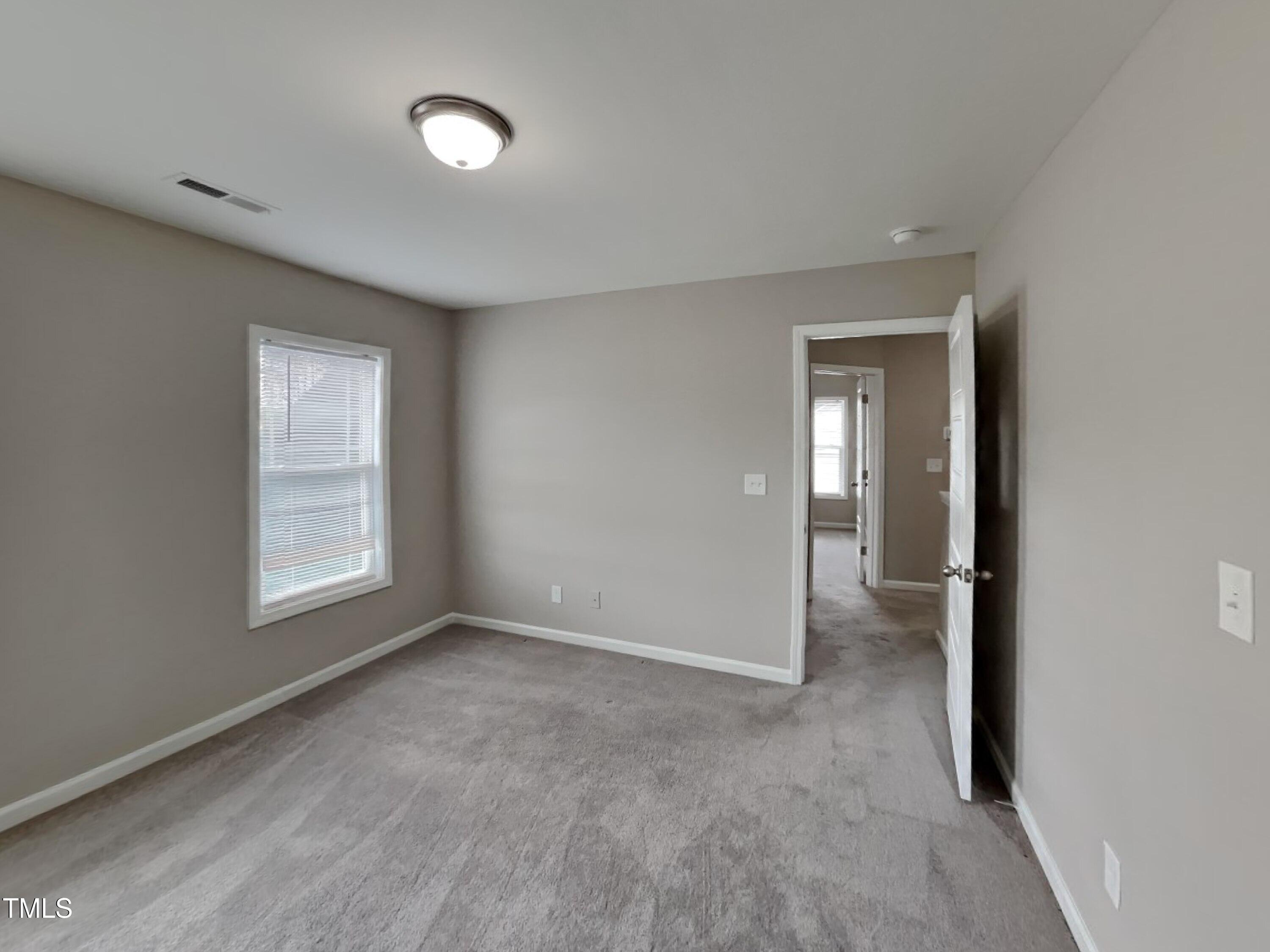 67 Weathervane Dr. Zebulon, NC 27597 - Photo 10 of 17 a view of an empty room with a window and a bathroom
