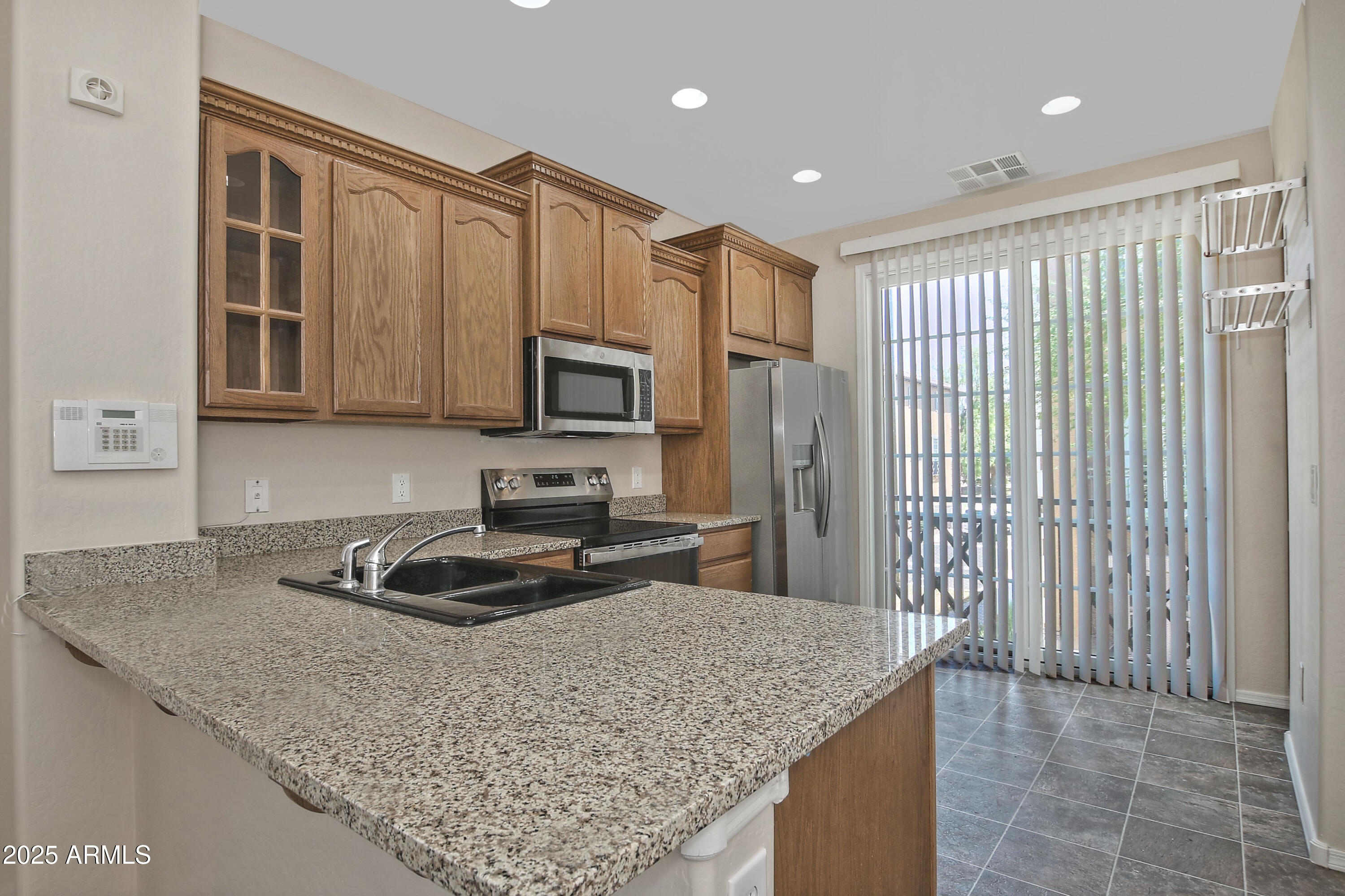 2785 South Alpine Drive Gilbert, AZ 85295 - Photo 11 of 31 a kitchen with kitchen island granite countertop stainless steel appliances a sink stove refrigerator and cabinets