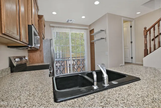a kitchen with granite countertop a stove a sink and a granite counter tops