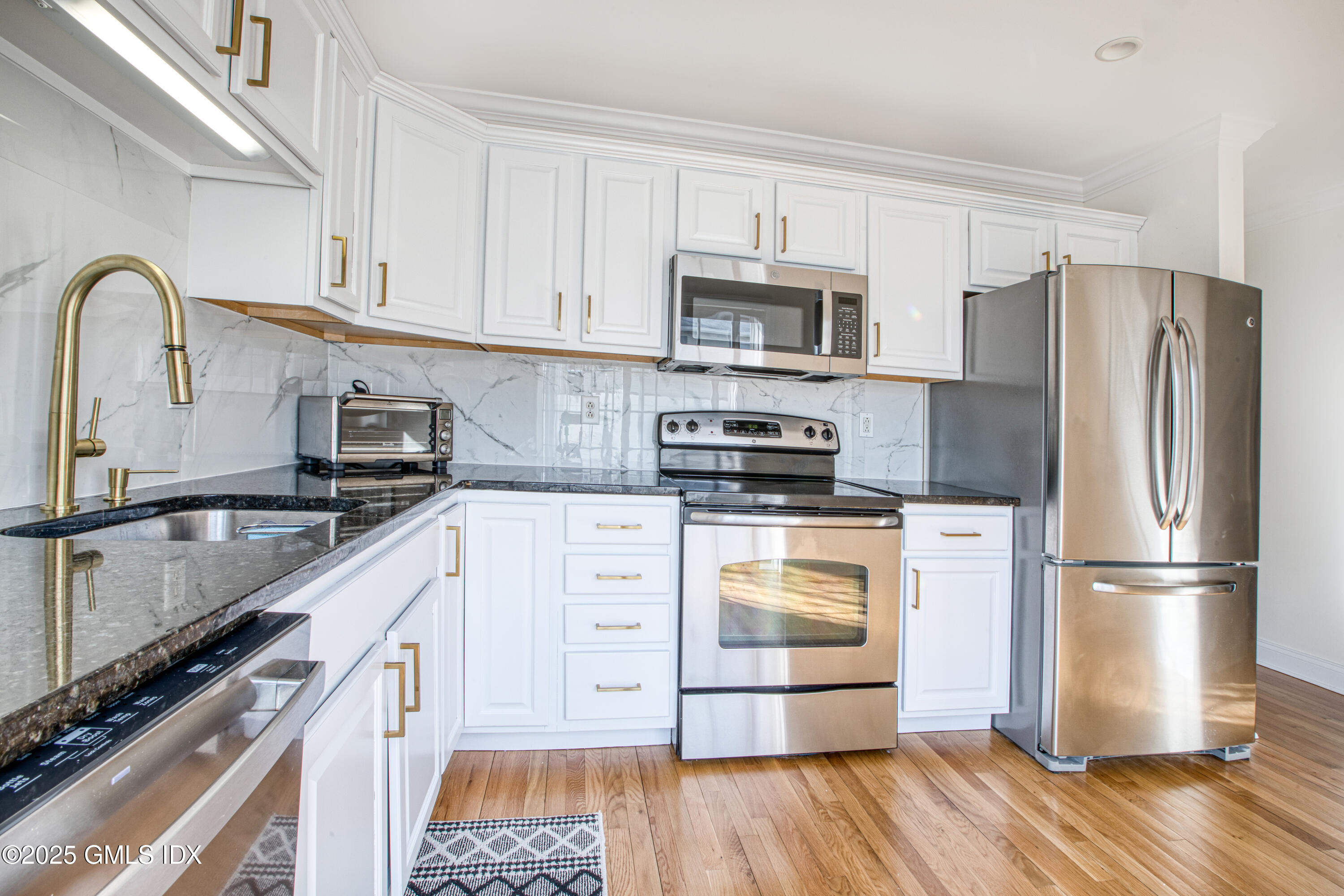39 Maple Tree Avenue, Unit 16 Stamford, CT 06906 - Photo 6 of 21 a kitchen with stainless steel appliances a refrigerator stove and white cabinets