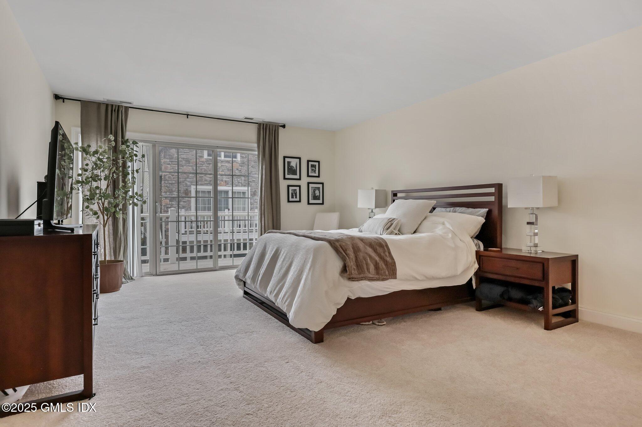 39 Maple Tree Avenue, Unit 16 Stamford, CT 06906 - Photo 8 of 21 a bedroom with a bed chair and a large window