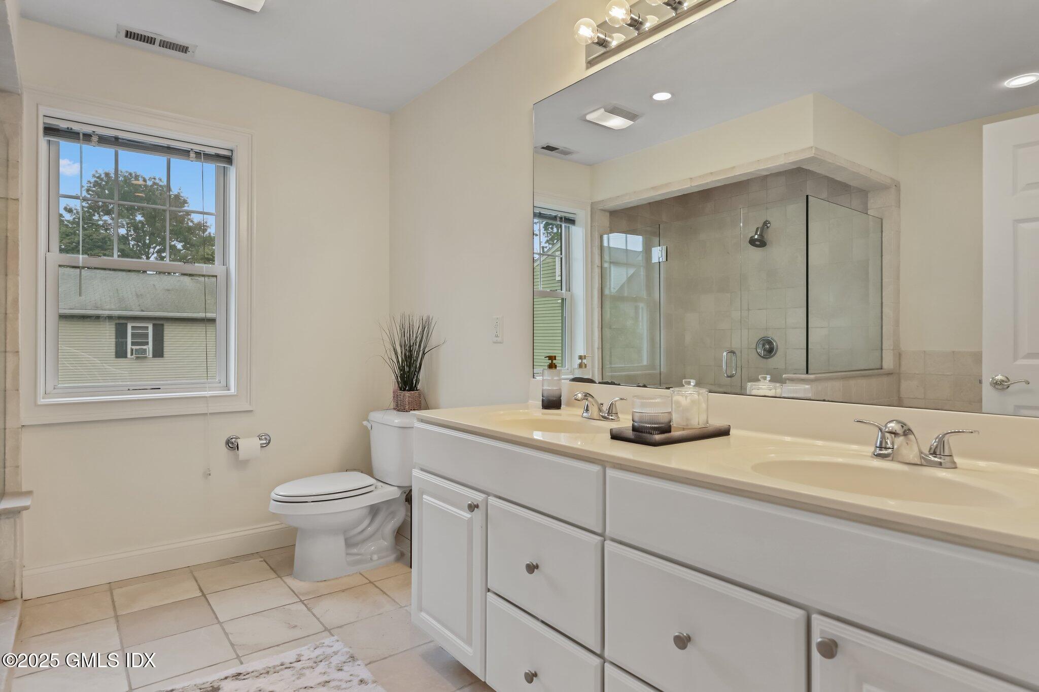 39 Maple Tree Avenue, Unit 16 Stamford, CT 06906 - Photo 10 of 21 a bath room with a toilet a sink and a mirror