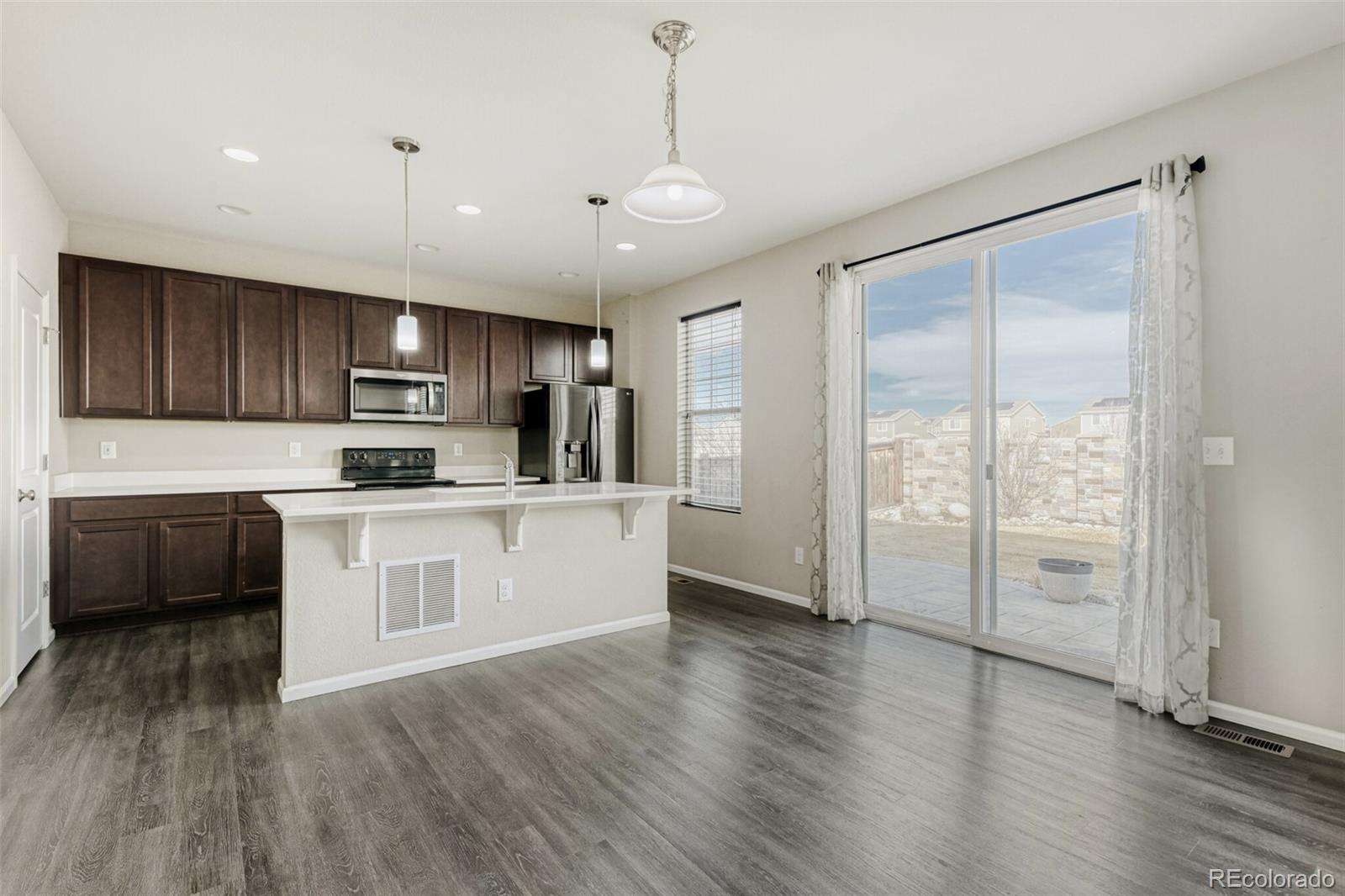 2725 East 159th Way Thornton, CO 80602 - Photo 11 of 36 a kitchen with stainless steel appliances a refrigerator sink and microwave
