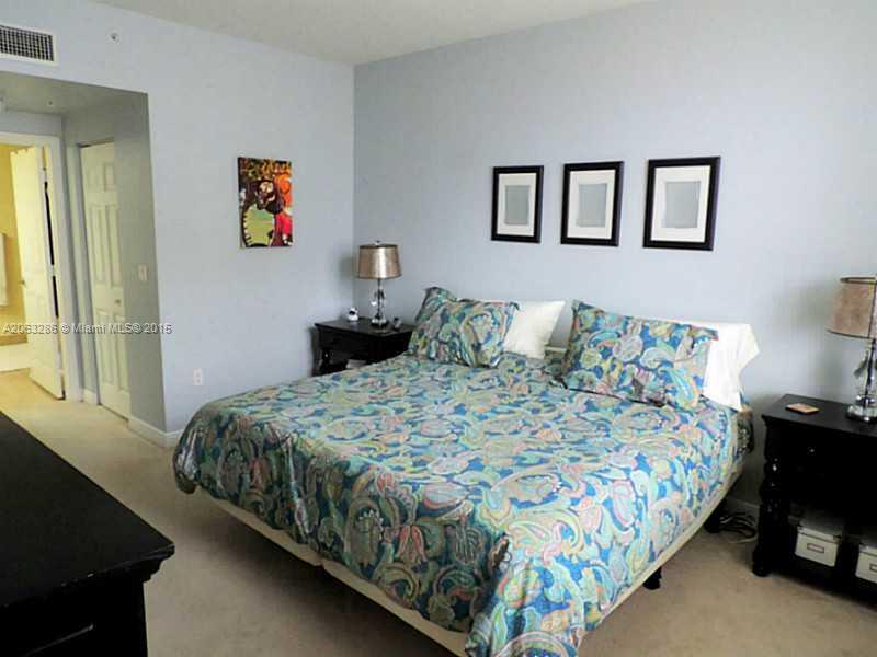 888 Douglas Road, Unit 1016 Coral Gables, FL 33134 - Photo 8 of 34 a bedroom with a bed and painting on the wall