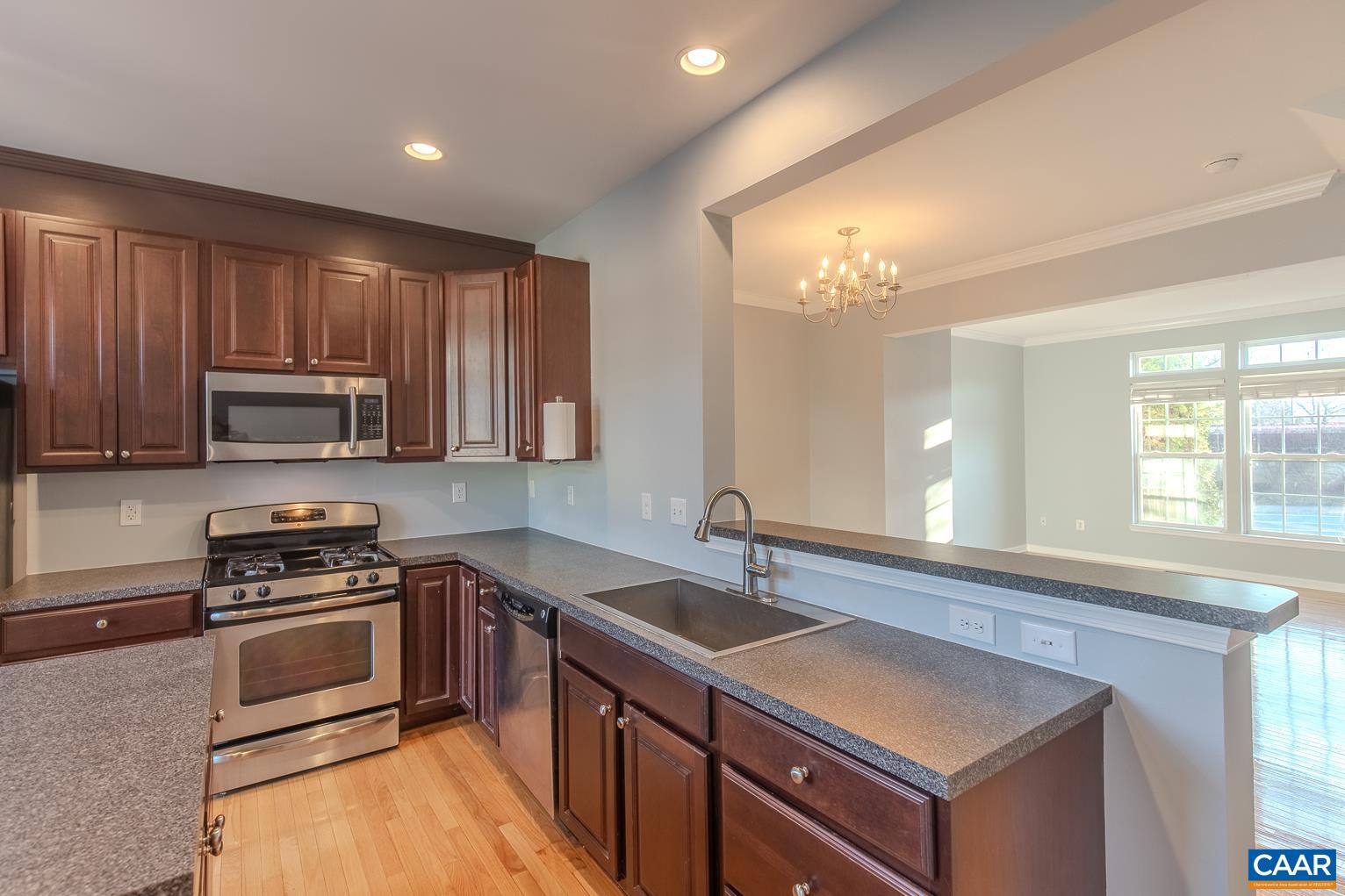 339 Rolkin Road Charlottesville, VA 22911 - Photo 11 of 43 a kitchen with wooden cabinets a sink and a stove