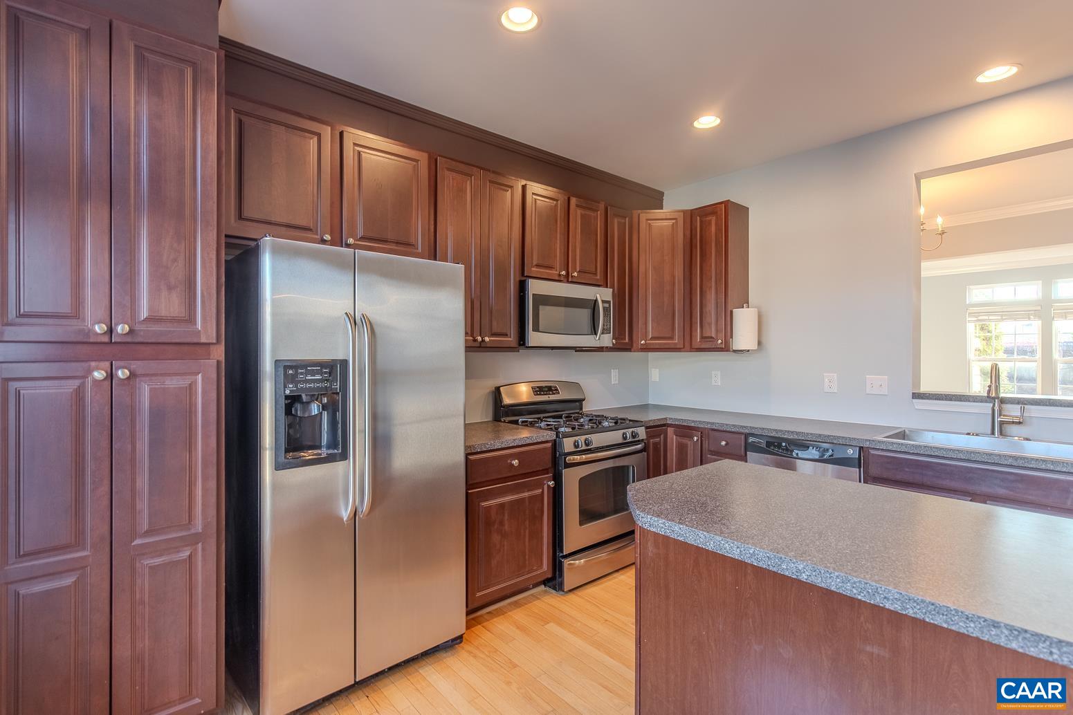 339 Rolkin Road Charlottesville, VA 22911 - Photo 12 of 43 a kitchen with stainless steel appliances granite countertop a refrigerator a sink a stove a microwave and island with wooden floor