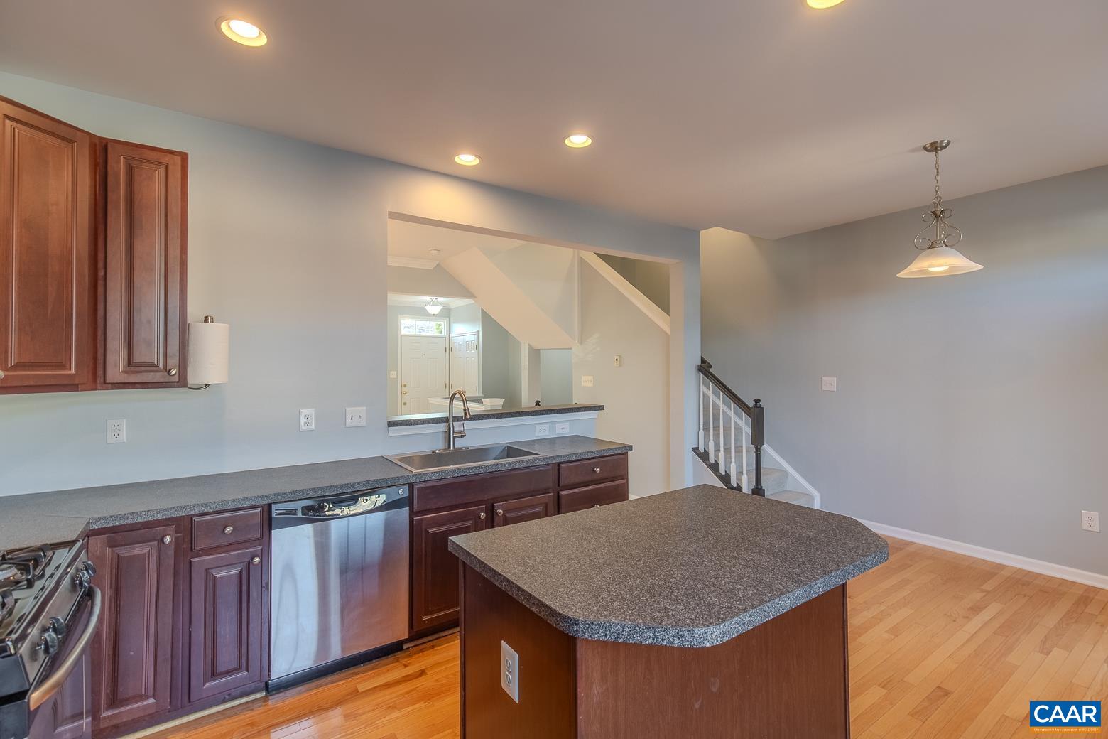 339 Rolkin Road Charlottesville, VA 22911 - Photo 14 of 43 a kitchen that has a sink a microwave oven a stove and white cabinets with wooden floor