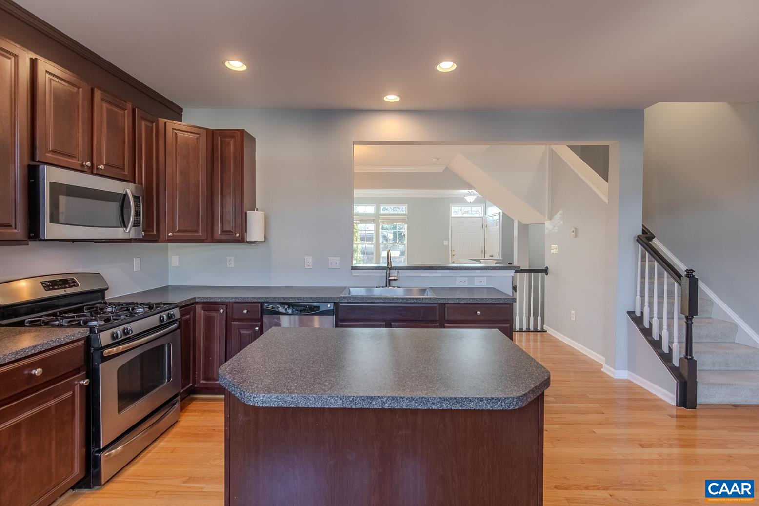 339 Rolkin Road Charlottesville, VA 22911 - Photo 10 of 43 a kitchen with granite countertop a sink a stove top oven and cabinetry