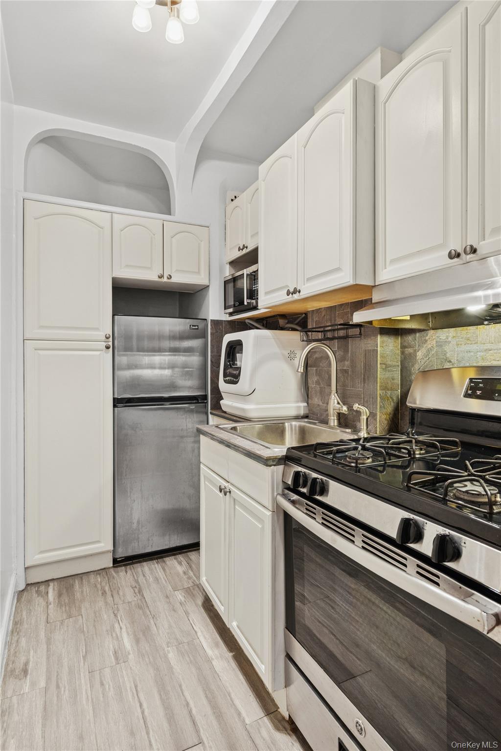 110-55 72nd Road, Unit 106 Queens, NY 11375 - Photo 5 of 10 a kitchen with appliances a sink and cabinets