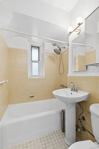 a bathroom with a sink mirror toilet and bathtub