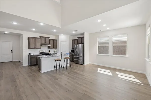 a kitchen with kitchen island granite countertop a sink stove and refrigerator