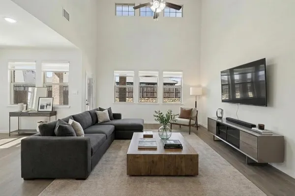 an empty room with windows and fan