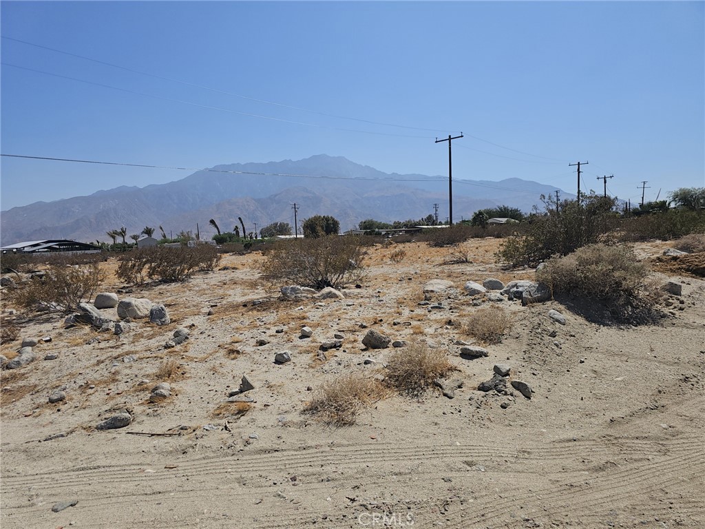 a view of a dry yard with mountains in the background
