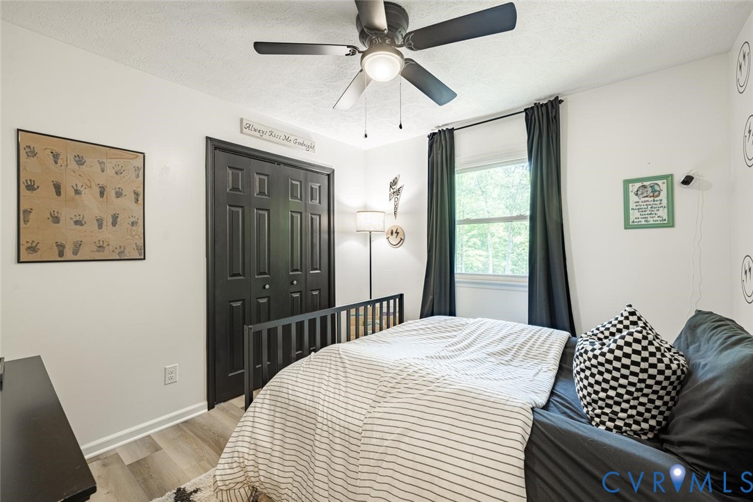 12397 New Market Mill Road Beaverdam, VA 23015 - Photo 21 of 44 a bedroom with a bed and a chandelier