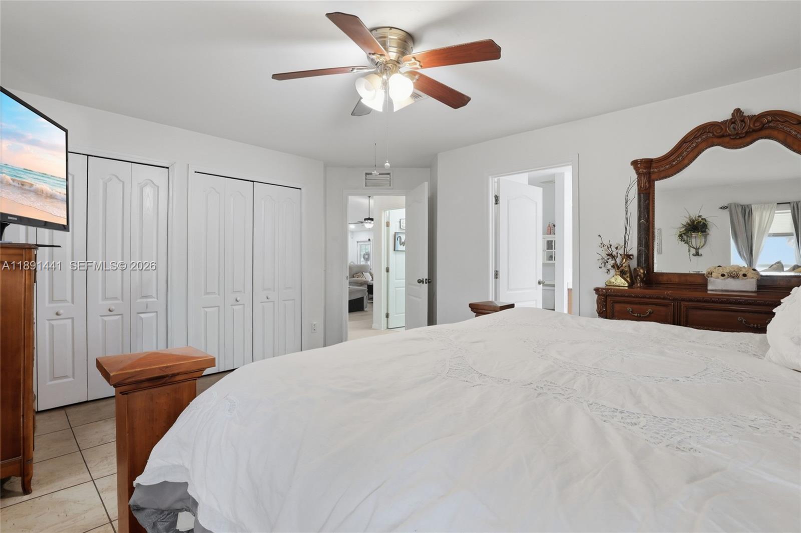 3003 25th Street West Lehigh Acres, FL 33971 - Photo 18 of 39 a bedroom with a bed and a chandelier