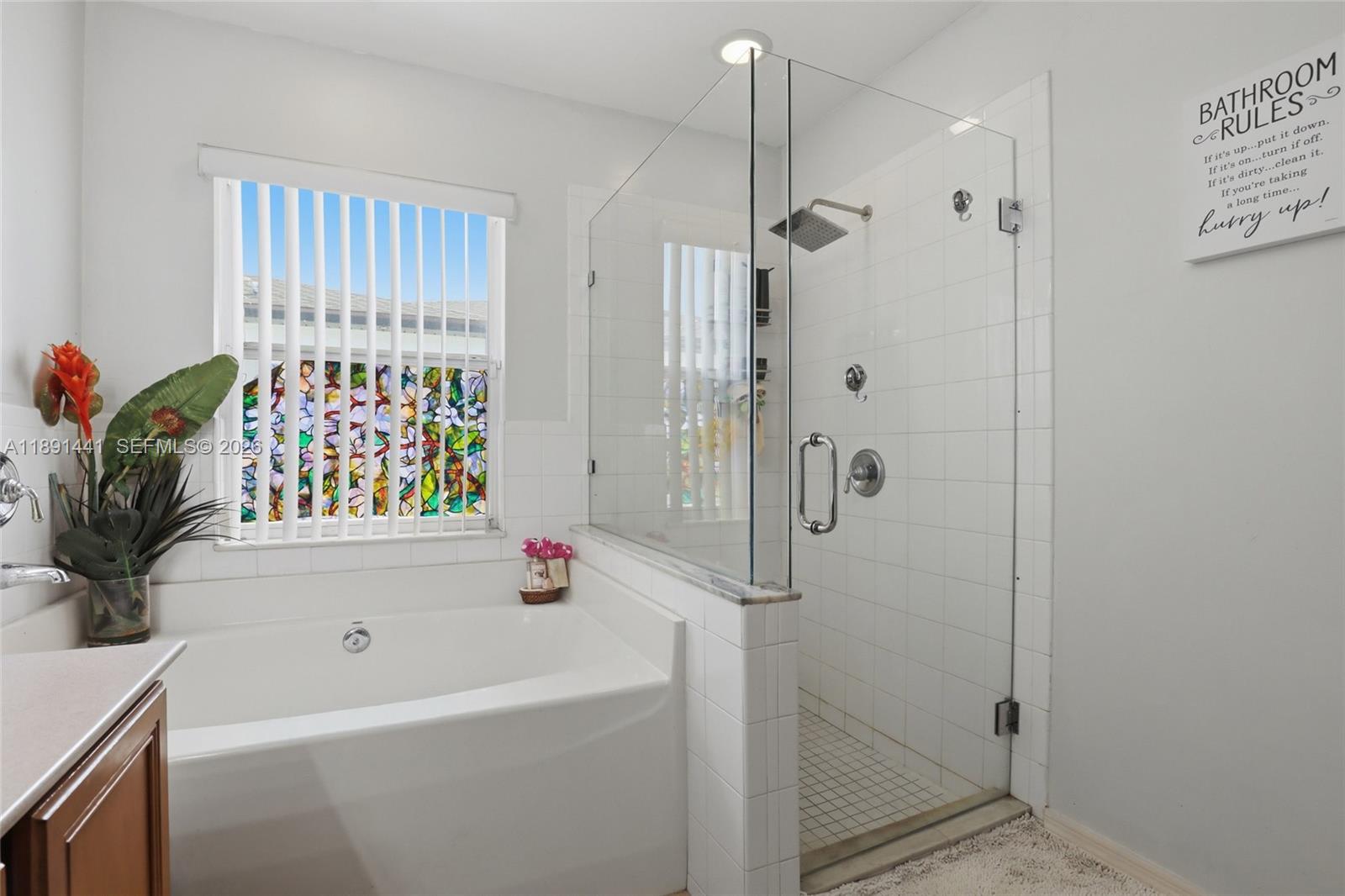 3003 25th Street West Lehigh Acres, FL 33971 - Photo 21 of 39 a bathroom with a bathtub a shower and a window