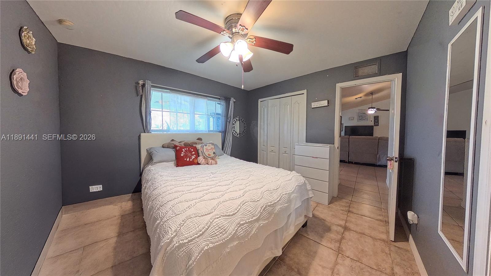 3003 25th Street West Lehigh Acres, FL 33971 - Photo 23 of 39 a bedroom with a large bed and a chandelier