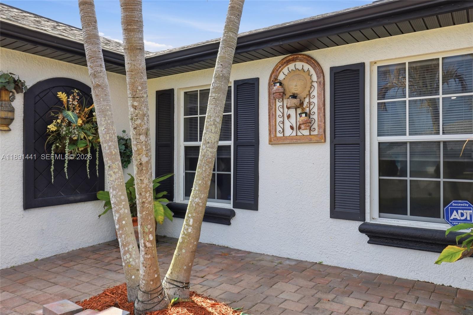 3003 25th Street West Lehigh Acres, FL 33971 - Photo 31 of 39 a front view of a house with outdoor seating and a potted plant