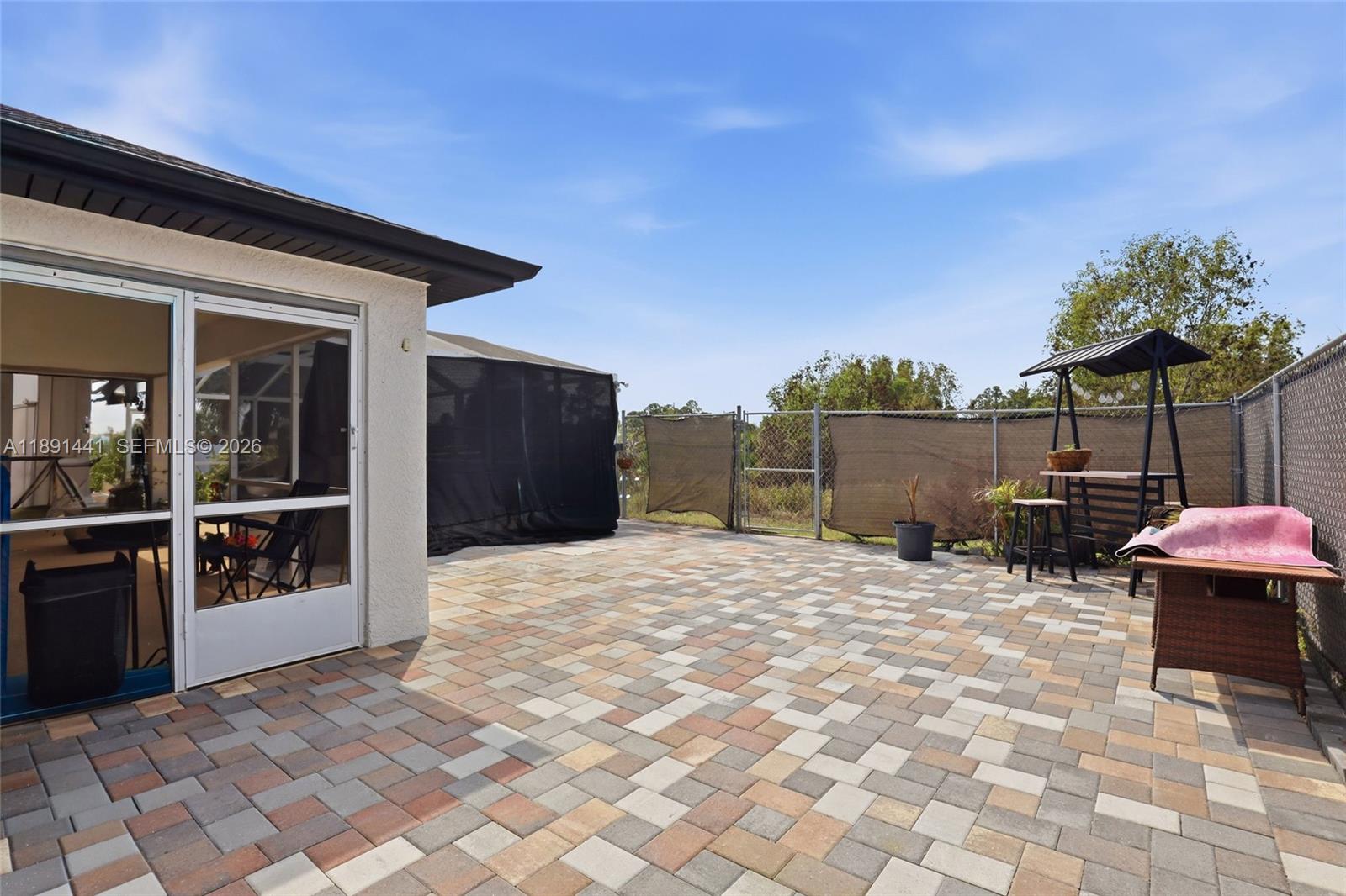 3003 25th Street West Lehigh Acres, FL 33971 - Photo 32 of 39 a backyard of a house with table and chairs