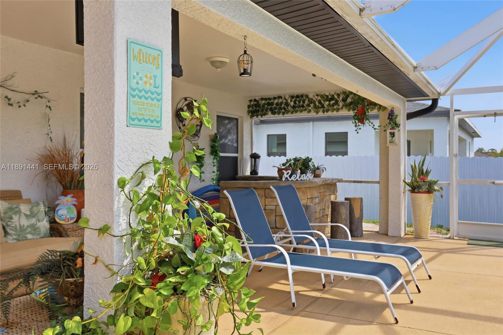 3003 25th Street West Lehigh Acres, FL 33971 - Photo 36 of 39 a view of a patio with table and chairs and potted plants