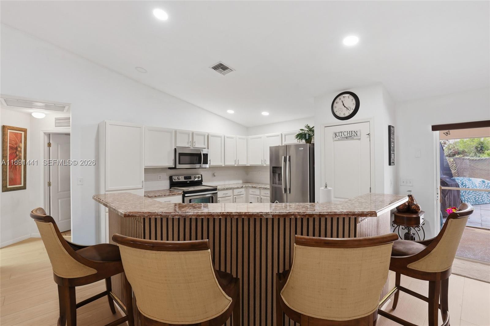 3003 25th Street West Lehigh Acres, FL 33971 - Photo 7 of 39 a kitchen with stainless steel appliances granite countertop a table chairs and a refrigerator