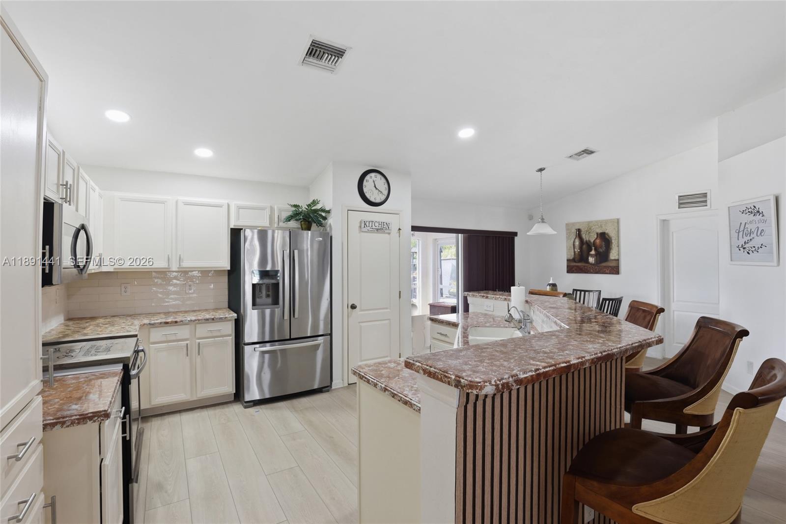 3003 25th Street West Lehigh Acres, FL 33971 - Photo 8 of 39 a kitchen with a refrigerator and a stove top oven