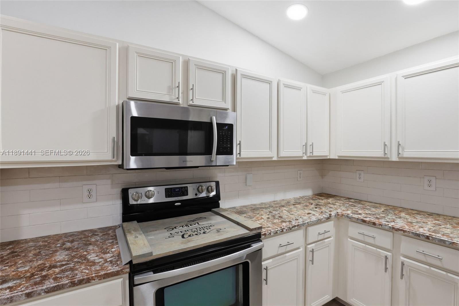 3003 25th Street West Lehigh Acres, FL 33971 - Photo 10 of 39 a kitchen with stainless steel appliances granite countertop a sink stove and microwave