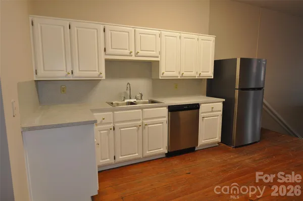 a kitchen with white cabinets and white appliances
