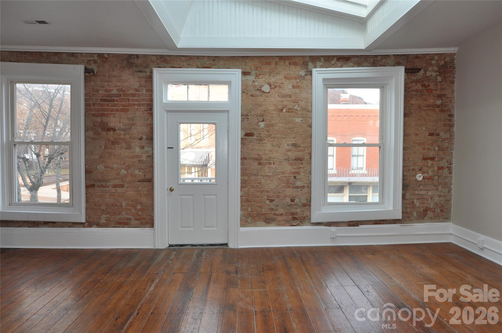 107 Gadsden Street, Unit A&B Chester, SC 29706 - Photo 7 of 20 an empty room with wooden floor and windows