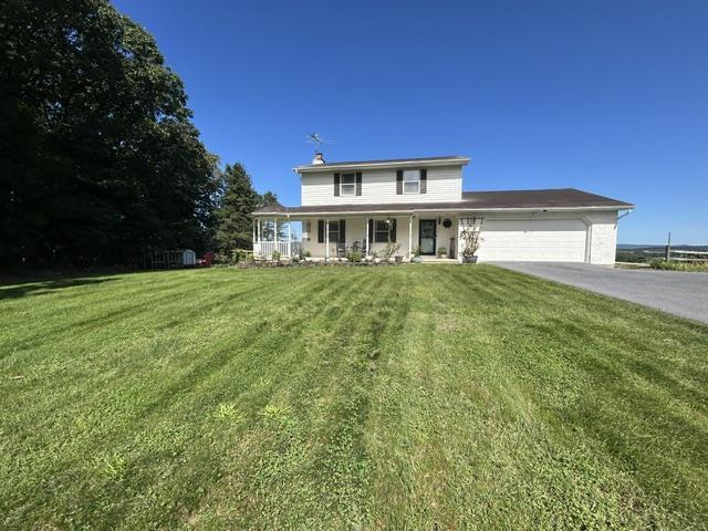9191 Red Road Kempton, PA 19529 - Photo 1 of 25 Manicured 1.5 acre green lawns frame this traditional multi-level residence under clear blue skies.